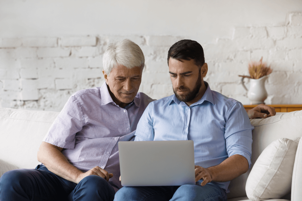 son and father on a couch reviewing aged care offerings and seeking to debunk aged care myths regarding RADs