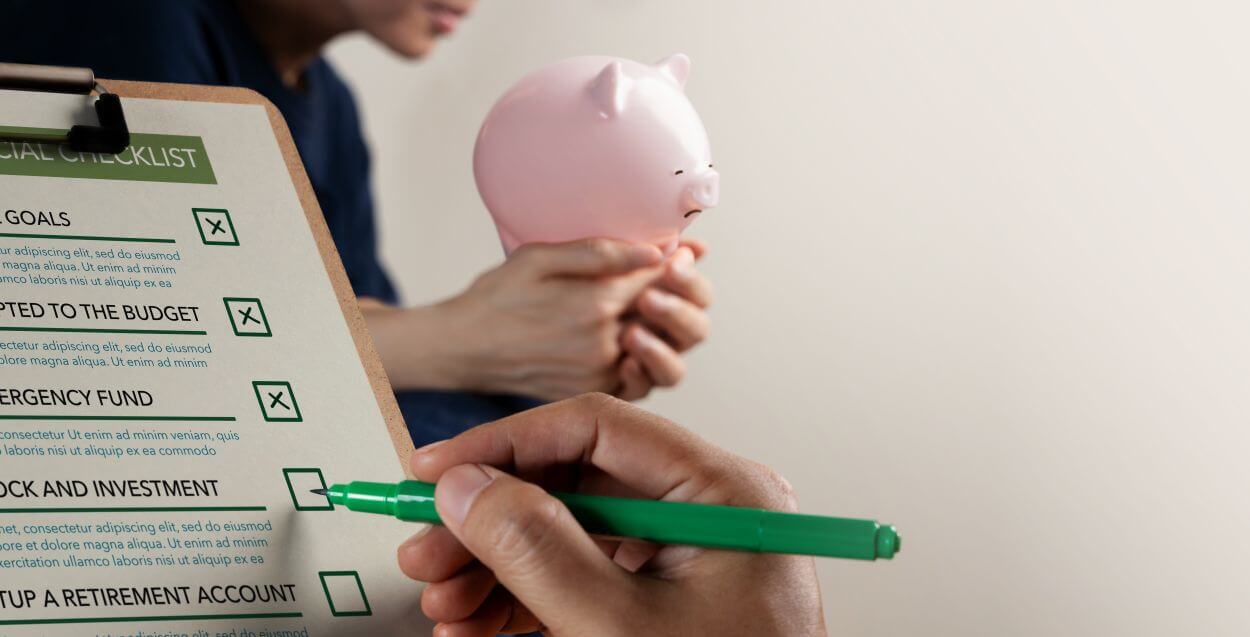 couple review their plan to grow financial assets to accumulate toward future goals and retirement: she holds a pink piggy bank representing their superannuation account; he ticks off a checklist of items to monitor progress
