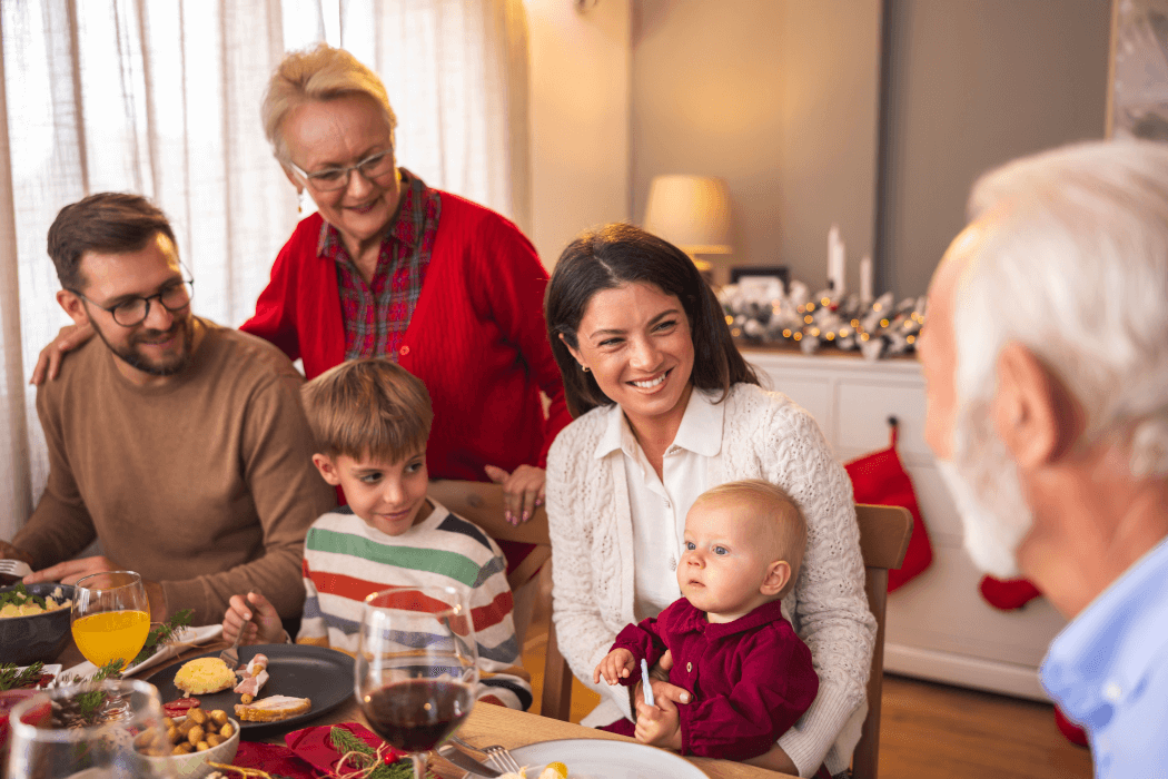 three generations of family gathered at a meal table discussing family matters and residential aged care not for them - a happy group of grandparents, parents an two children - learning the value of financial advice from senior family members