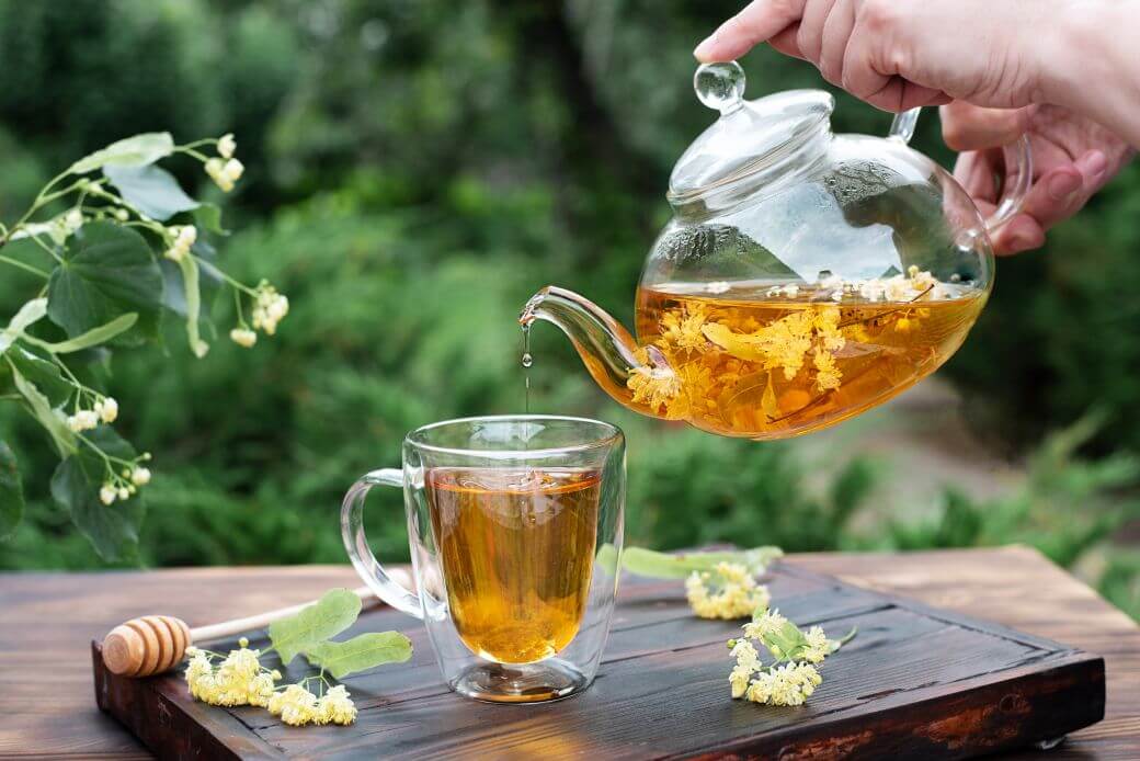 herbal tea being poured from a clear glass teapot into an insulated clear galss cup providing a simple plasant afternoon tea - an ideal way to contemplate the superannuation contribution opportunities