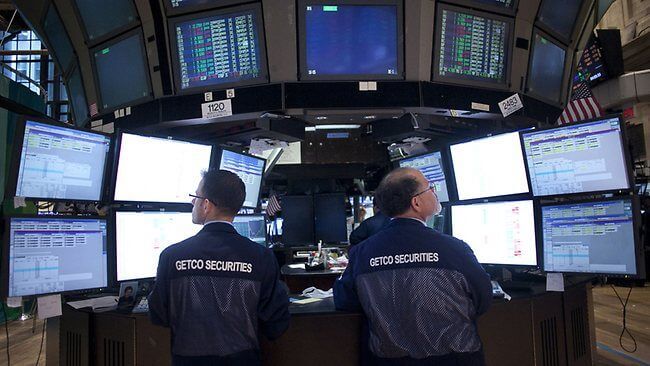 traders on the sharemarket floor in front of screens and monitoring trades in listed investments on the New York Stock Exchange. Their continued existence, evidence of investment market strength