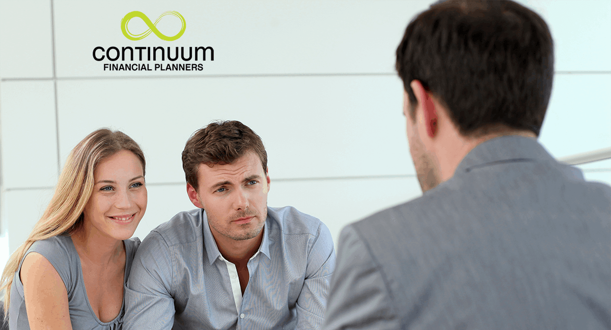 a young couple being guided by their financial planner to review their Investor risk profile and to consider adjusting their portfolio