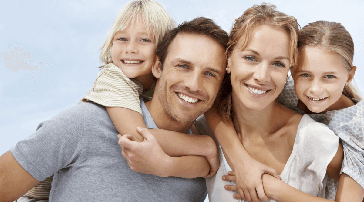 contented young family smiling and hugging, comforted that they are secure with income protection insurance, outsourcing risk management