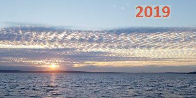 an image of a new day dawninbg over the ocean with some clouds on the horizon and the year 2019 embedded in red numbering in the sky, prompting reflection on the economic and markets outlook for 2019