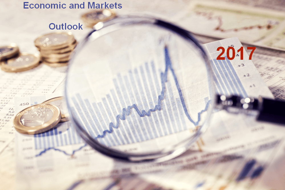 magnifying glass held over a table covered with charts and coins signifying an outlook on economic and market conditions for 2017
