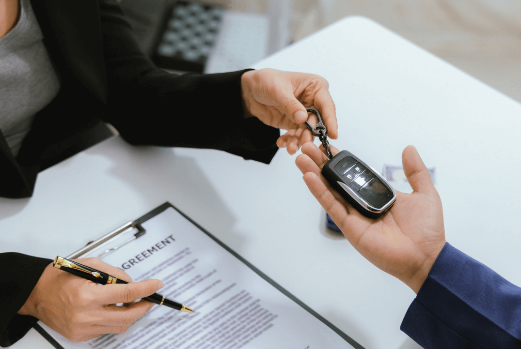 man receiving keys to a business across the table from the previous owner as they review the terms of their business succession agreement