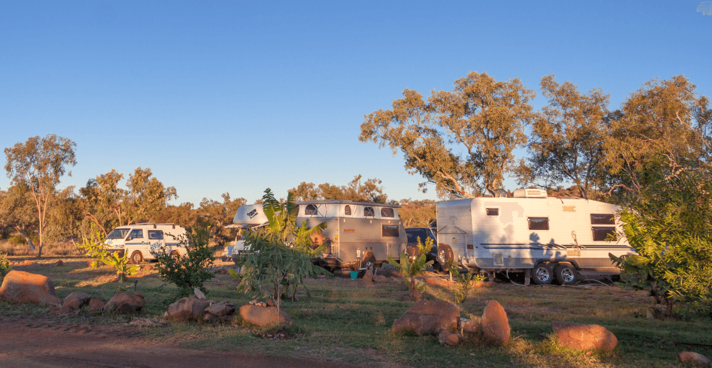 group of caravans and motorhomes at a camping ground as goals achieved allow time and travel