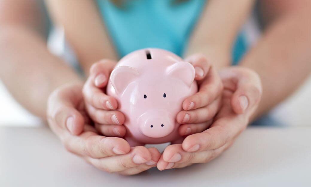 a mother's hands nurture her daughter's hands, which in turn nestle a pink piggy bank representing mum's superannuation - that will benefit the daughter from her estate