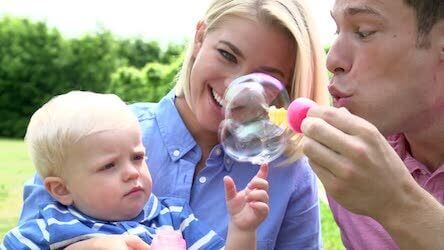 a happy young couple with their young child are confident in the education fuding options they have in place for her