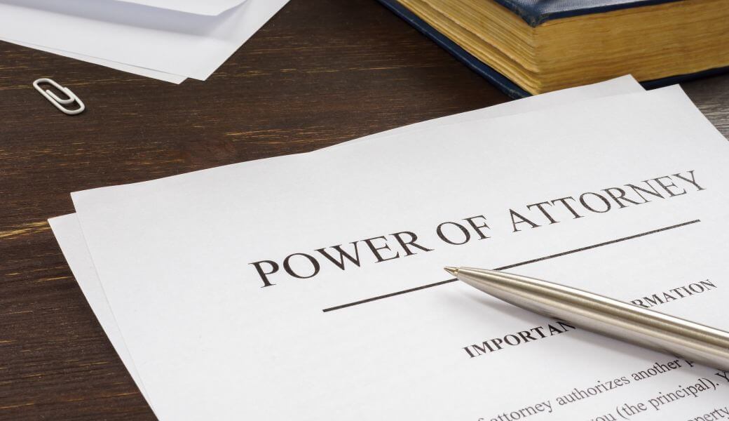 power of attorney document being prepared at a desk with other stationary and reference books surrounding it