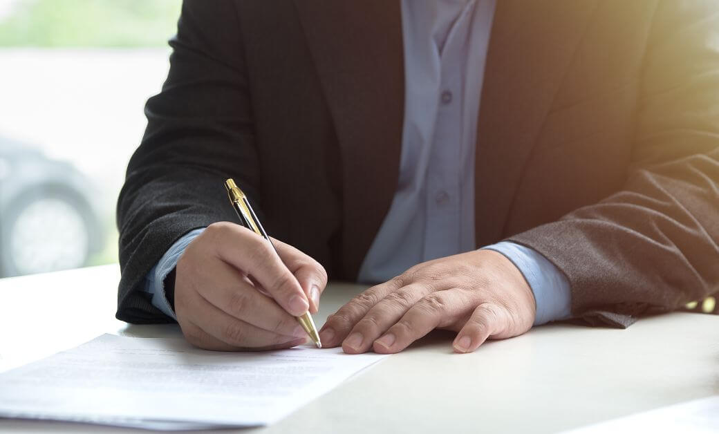 male in business suit signing a formal document, could be to nominate a superannuation beneficiary as part of his estate planning