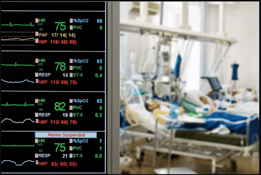 a composite image showing an iny=tensive care unit with two patients being monitored to the right of the image, and screen shot of monitoring the vital statistics of one of them - highlighting the intensity of an unexpected health matter for which business-centric life insurance would mitigate financial burden