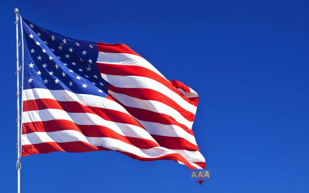 image of US flag in bright sunlight but sagging as it is weighed down by a downgrade from AAA credit rating - all set against a bright blue background