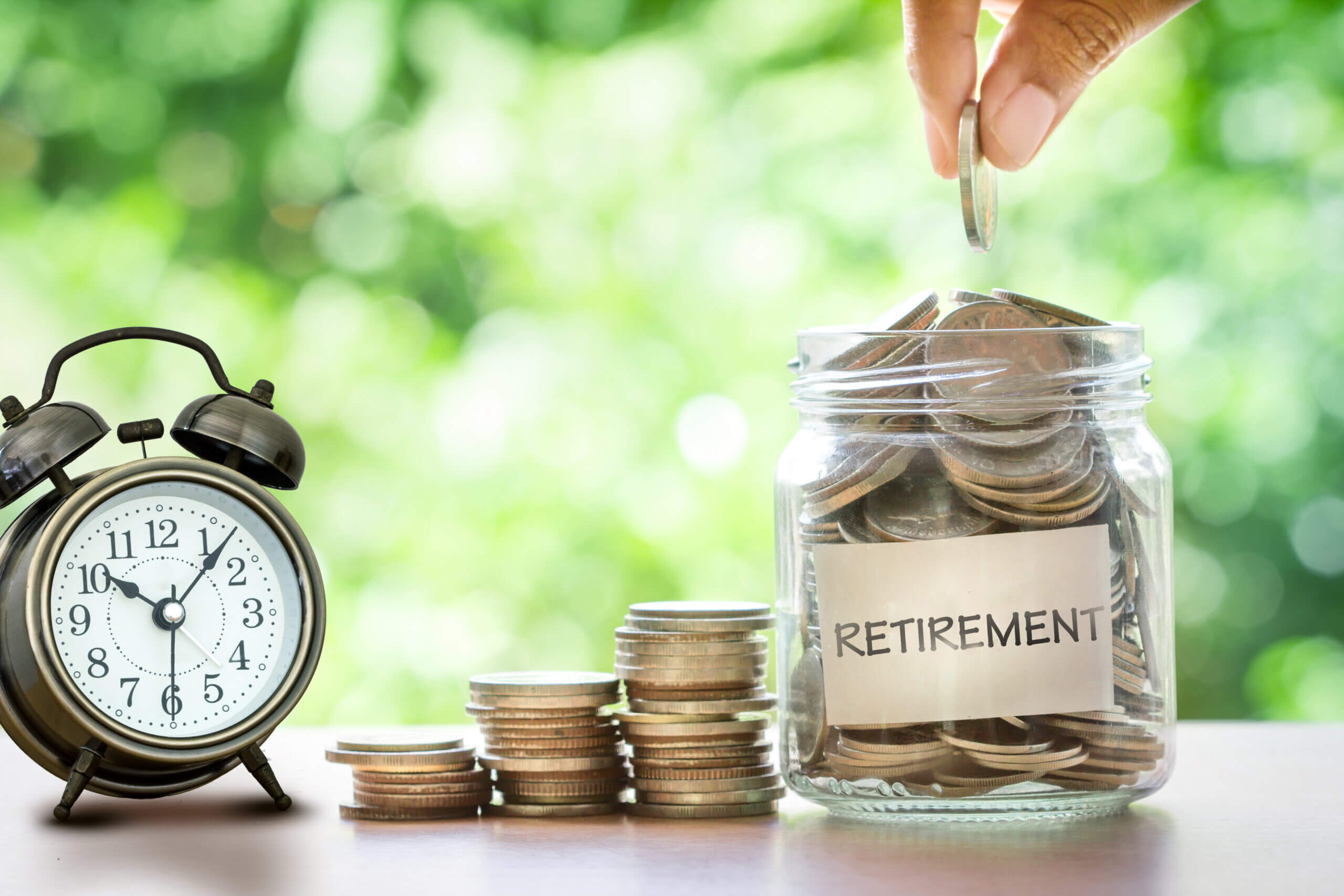 Alarm clock counting down to retirement with money accumulating for retirement through volatile market conditions