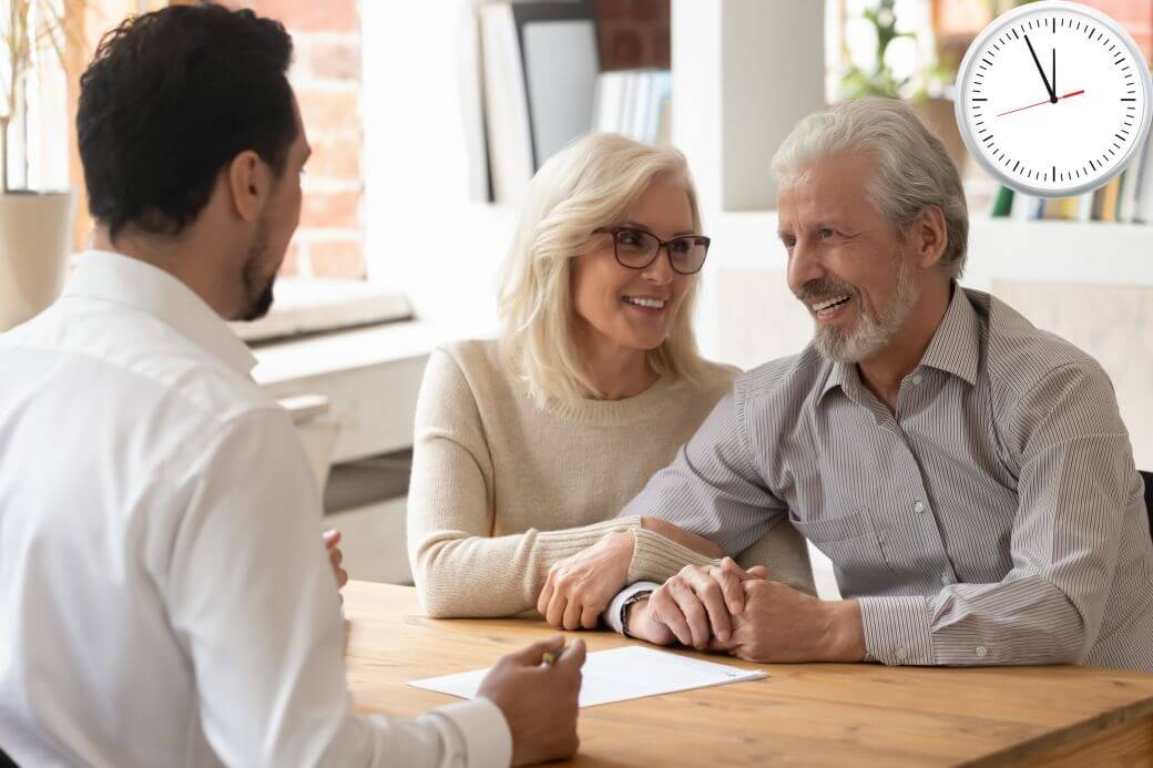 couple meeting adviser under a looming clock showing that it is 5 minutes to 12 o'clock - urgently seeking to Act Now on their Estate Planning