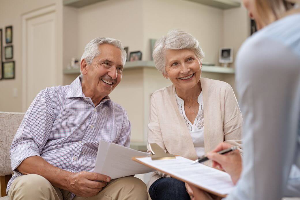 happy grandparents smiling as they discuss helping their grandchild enter the housing market having given careful consideration to all financial and family aspects